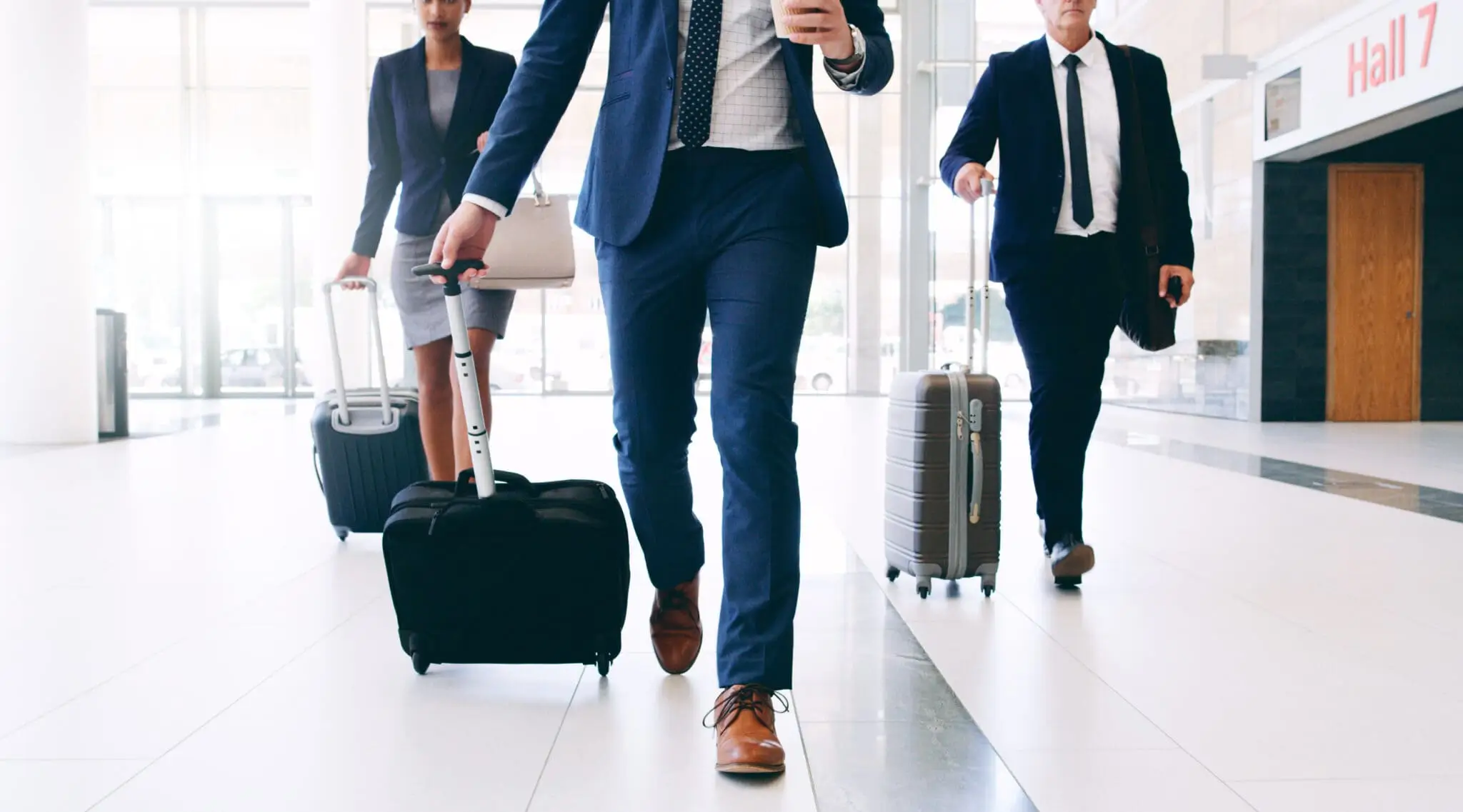 Tres empresarios recorriendo el aeropuerto con sus maletas